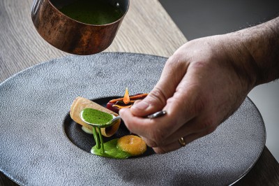 Miniature Location salle Vignieu (Isère) - Domaine de Suzel #47 Chambre avec lit rond, couverture rouge, pétales de rose, lampe de chevet et plafond en bois avec suspension plumeuse.