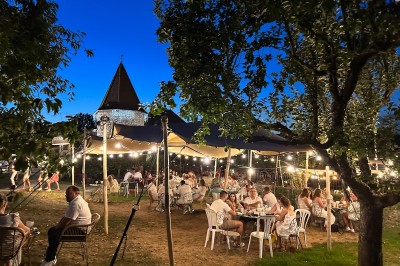 Miniature Location salle Vignieu (Isère) - Domaine de Suzel #48 Chambre avec lit rond, couverture rouge, pétales de rose, lampe de chevet et plafond en bois avec suspension plumeuse.