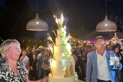 Miniature Location salle Vignieu (Isère) - Domaine de Suzel #50 Chambre avec lit rond, couverture rouge, pétales de rose, lampe de chevet et plafond en bois avec suspension plumeuse.
