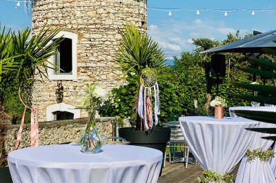 Miniature Location salle Vignieu (Isère) - Domaine de Suzel #57 Chambre avec lit rond, couverture rouge, pétales de rose, lampe de chevet et plafond en bois avec suspension plumeuse.