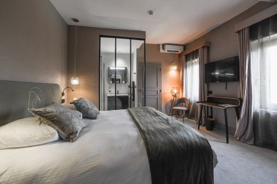 Un couple de dos regarde un feu d'artifice illuminer le ciel nocturne dans un cadre extérieur.