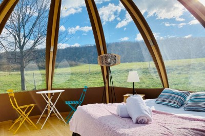 Un couple de dos regarde un feu d'artifice illuminer le ciel nocturne dans un cadre extérieur.