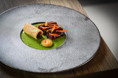 Un couple de dos regarde un feu d'artifice illuminer le ciel nocturne dans un cadre extérieur.