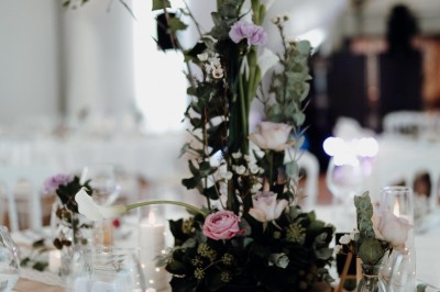 Un couple de dos regarde un feu d'artifice illuminer le ciel nocturne dans un cadre extérieur.
