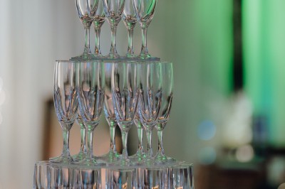 Un couple de dos regarde un feu d'artifice illuminer le ciel nocturne dans un cadre extérieur.