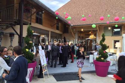 Miniature Location salle Vignieu (Isère) - Domaine de Suzel #16 Chambre avec lit rond, couverture rouge, pétales de rose, lampe de chevet et plafond en bois avec suspension plumeuse.