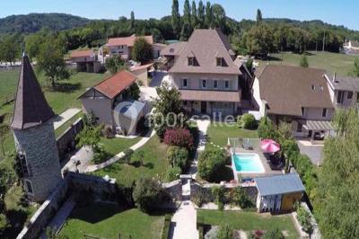 Miniature Location salle Vignieu (Isère) - Domaine de Suzel #3 Chambre avec lit rond, couverture rouge, pétales de rose, lampe de chevet et plafond en bois avec suspension plumeuse.
