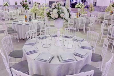 Salle de réception spacieuse avec piste de danse, éclairages colorés et équipement audio sur une estrade.