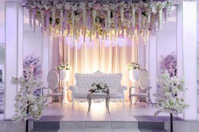 Salle de réception spacieuse avec piste de danse, éclairages colorés et équipement audio sur une estrade.