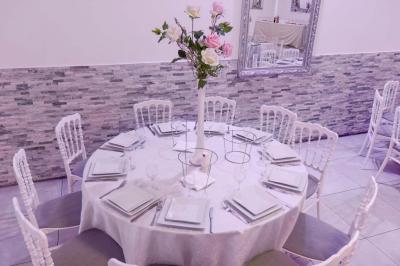 Salle de réception spacieuse avec piste de danse, éclairages colorés et équipement audio sur une estrade.