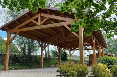 Chambre avec un lit double, draps rayés verts, table de chevet en bois, lampes et sol carrelé beige.