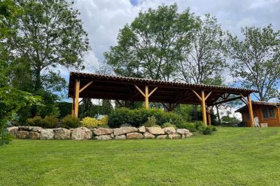Chambre avec un lit double, draps rayés verts, table de chevet en bois, lampes et sol carrelé beige.