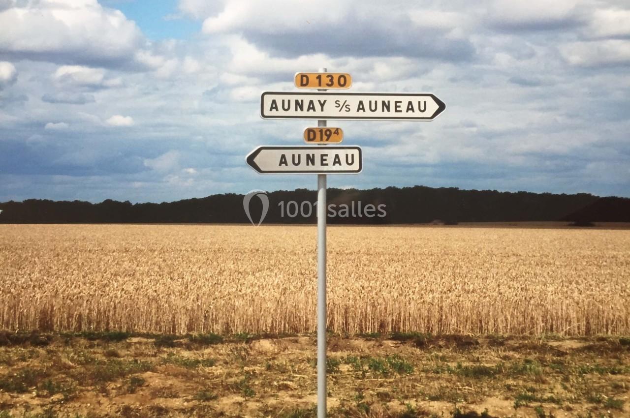 Panneau de signalisation indiquant les directions vers Aunay-sous-Auneau et Auneau, devant un champ de blé sous un ciel…