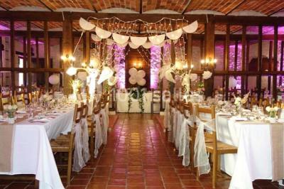 Chambre lumineuse avec deux lits simples, sol en carrelage, plafond en bois, et vue sur un jardin depuis une porte ouverte.