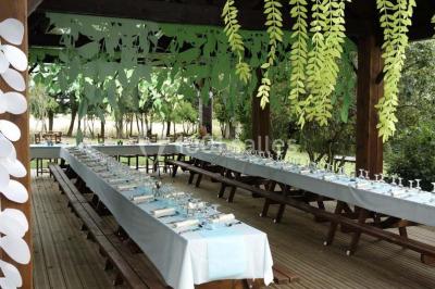 Chambre lumineuse avec deux lits simples, sol en carrelage, plafond en bois, et vue sur un jardin depuis une porte ouverte.