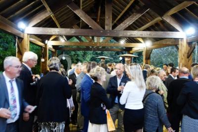 Chambre lumineuse avec deux lits simples, sol en carrelage, plafond en bois, et vue sur un jardin depuis une porte ouverte.