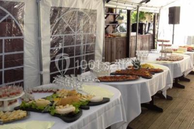Chambre lumineuse avec deux lits simples, sol en carrelage, plafond en bois, et vue sur un jardin depuis une porte ouverte.