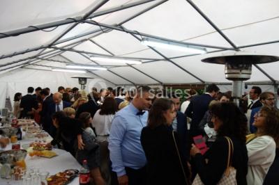 Chambre lumineuse avec deux lits simples, sol en carrelage, plafond en bois, et vue sur un jardin depuis une porte ouverte.