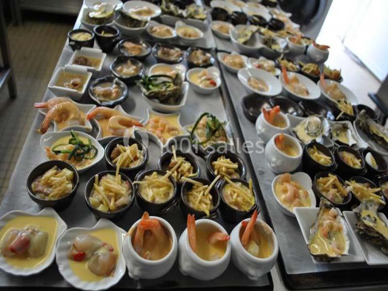 Plateaux garnis de petites portions variées comprenant fruits de mer, légumes, sauces et accompagnements.