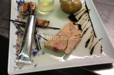 Tranche de foie gras en millefeuille avec décoration de fruits, sauce rouge et bâtonnets en chocolat.