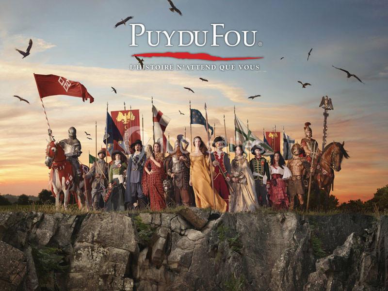 Groupe de personnages en costumes historiques sur une falaise, entourés de drapeaux et d'oiseaux en vol.
