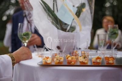 Étang calme reflétant des arbres et une pelouse verdoyante avec un bunker de golf en arrière-plan.