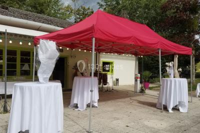 Étang calme reflétant des arbres et une pelouse verdoyante avec un bunker de golf en arrière-plan.