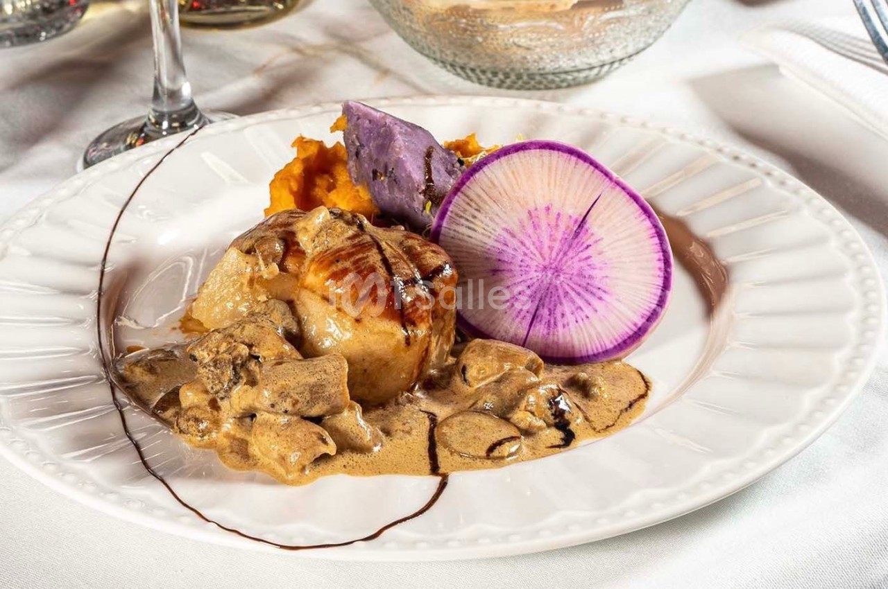 Assiette gastronomique avec viande en sauce, purées colorées, tranche de radis violet et décoration soignée.
