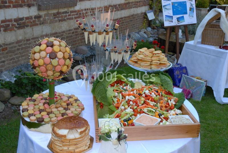 Buffet en extérieur avec macarons, crêpes, brochettes de fruits et plateau de crudités accompagné de sauces.
