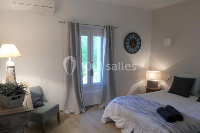 Miniature Location salle Montagnac (Hérault) - Domaine de la Grangette #27 Tente en toile beige installée sur un sol gravillonné, entourée d'arbres, avec des lits aménagés à l'intérieur.