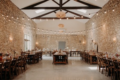 Miniature Location salle Montagnac (Hérault) - Domaine de la Grangette #9 Tente en toile beige installée sur un sol gravillonné, entourée d'arbres, avec des lits aménagés à l'intérieur.