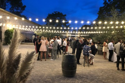 Miniature Location salle Montagnac (Hérault) - Domaine de la Grangette #14 Tente en toile beige installée sur un sol gravillonné, entourée d'arbres, avec des lits aménagés à l'intérieur.
