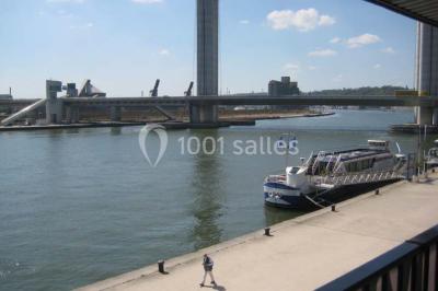 Miniature Location salle Rouen (Seine-Maritime) - Vue Sur Seine #2 Espace intérieur lumineux avec fauteuils rouges et noirs, tables hautes, plantes et stands d'exposition en arrière-plan.