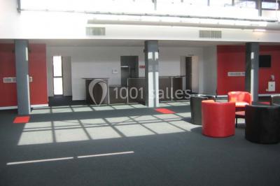 Miniature Location salle Rouen (Seine-Maritime) - Vue Sur Seine #10 Espace intérieur lumineux avec fauteuils rouges et noirs, tables hautes, plantes et stands d'exposition en arrière-plan.