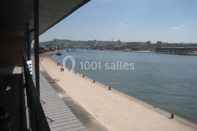 Miniature Location salle Rouen (Seine-Maritime) - Vue Sur Seine #12 Espace intérieur lumineux avec fauteuils rouges et noirs, tables hautes, plantes et stands d'exposition en arrière-plan.