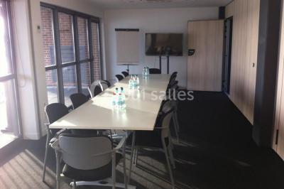 Miniature Location salle Rouen (Seine-Maritime) - Vue Sur Seine #13 Espace intérieur lumineux avec fauteuils rouges et noirs, tables hautes, plantes et stands d'exposition en arrière-plan.