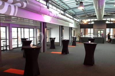 Miniature Location salle Rouen (Seine-Maritime) - Vue Sur Seine #16 Espace intérieur lumineux avec fauteuils rouges et noirs, tables hautes, plantes et stands d'exposition en arrière-plan.