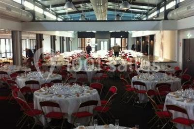 Miniature Location salle Rouen (Seine-Maritime) - Vue Sur Seine #19 Espace intérieur lumineux avec fauteuils rouges et noirs, tables hautes, plantes et stands d'exposition en arrière-plan.