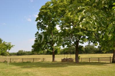 Miniature Location salle Le Crès (Hérault) - Domaine du Mas du Pont #11 Un couple en tenue de mariage pose devant un groupe de cavaliers alignés sur des chevaux dans un espace verdoyant.