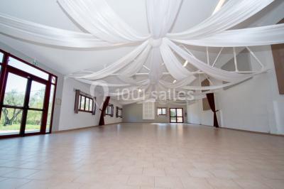Miniature Location salle Le Crès (Hérault) - Domaine du Mas du Pont #24 Un couple en tenue de mariage pose devant un groupe de cavaliers alignés sur des chevaux dans un espace verdoyant.