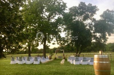 Miniature Location salle Le Crès (Hérault) - Domaine du Mas du Pont #28 Un couple en tenue de mariage pose devant un groupe de cavaliers alignés sur des chevaux dans un espace verdoyant.
