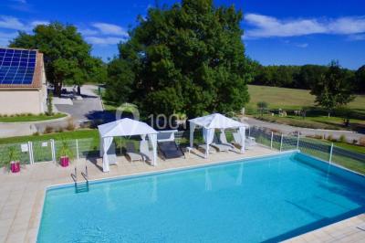 Miniature Location salle Le Crès (Hérault) - Domaine du Mas du Pont #7 Un couple en tenue de mariage pose devant un groupe de cavaliers alignés sur des chevaux dans un espace verdoyant.