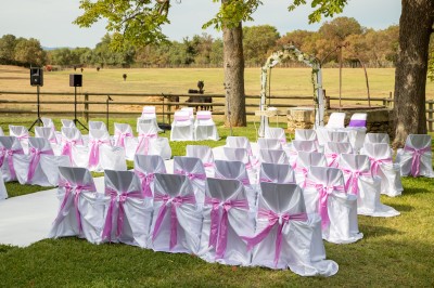 Miniature Location salle Le Crès (Hérault) - Domaine du Mas du Pont #13 Un couple en tenue de mariage pose devant un groupe de cavaliers alignés sur des chevaux dans un espace verdoyant.