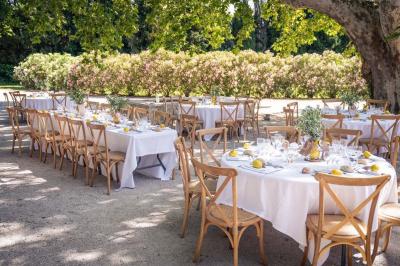 Miniature Location salle Avignon (Vaucluse) - Domaine de Rochegude #2 Façade d'une maison provençale avec terrasse ombragée, tables en fer forgé et grand arbre au premier plan.