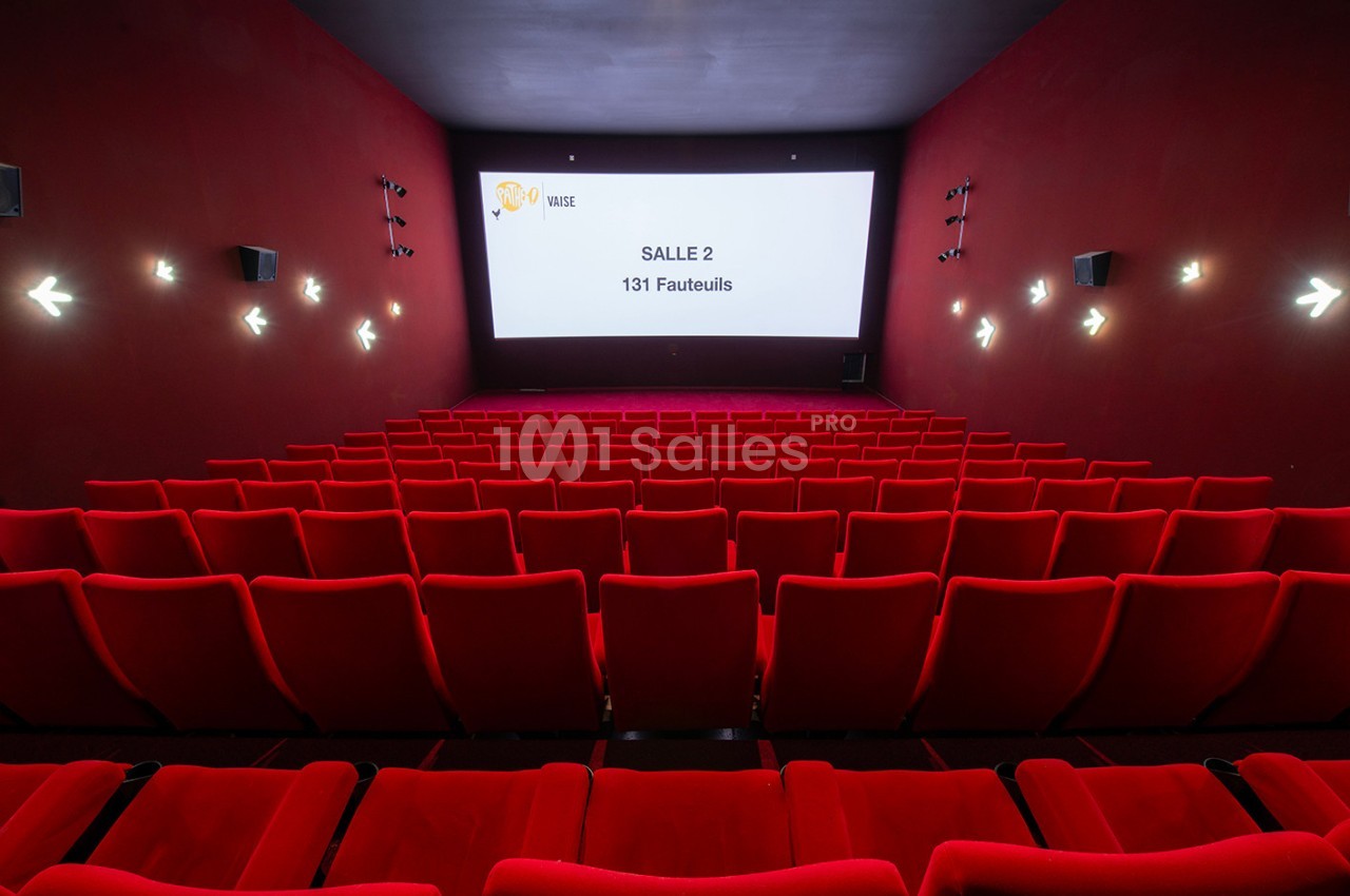 Salle de cinéma vide avec des rangées de fauteuils rouges et un écran affichant ’Salle 2 - 131 Fauteuils’.