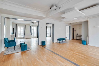 Façade d'un immeuble haussmannien avec balcons en fer forgé et fenêtres alignées sur plusieurs étages.