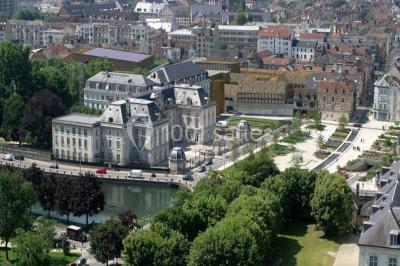 Un groupe de musiciens joue sur scène pendant qu'un public danse dans une salle éclairée et animée.