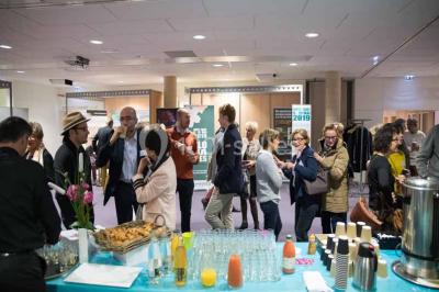 Un groupe de musiciens joue sur scène pendant qu'un public danse dans une salle éclairée et animée.