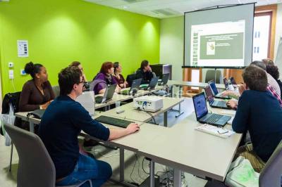 Un groupe de musiciens joue sur scène pendant qu'un public danse dans une salle éclairée et animée.