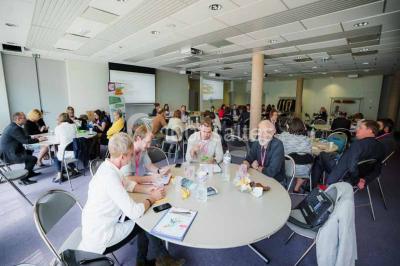 Un groupe de musiciens joue sur scène pendant qu'un public danse dans une salle éclairée et animée.